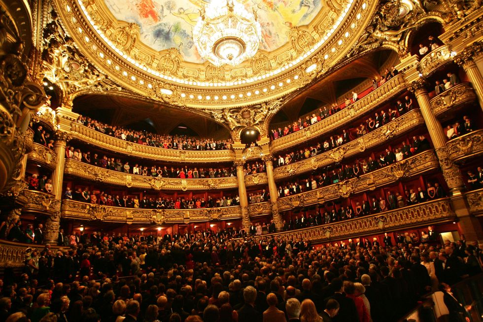 <p>Housing a 1,979-seat <a href="https://www.operadeparis.fr/en/visits/palais-garnier" target="_blank">opera house</a>, Palais Garnier features as grand a staircase as you could ever wish to see, along with a massive, glittering chandelier suspended from the theater's domed-mural ceiling, painted by Russian-French artist Marc Chagall. Take in a ballet or an opera for a night of opulence and culture. And after the performance, head to <a href="http://www.opera-restaurant.fr/en/" target="_blank">L'Opera Restaurant</a>—also at Palais Garnier—for high-end French cuisine in a beautifully designed space. It's a favorite of Victoria Beckham, Alber Elbaz, and Jean Paul Gaultier.</p>