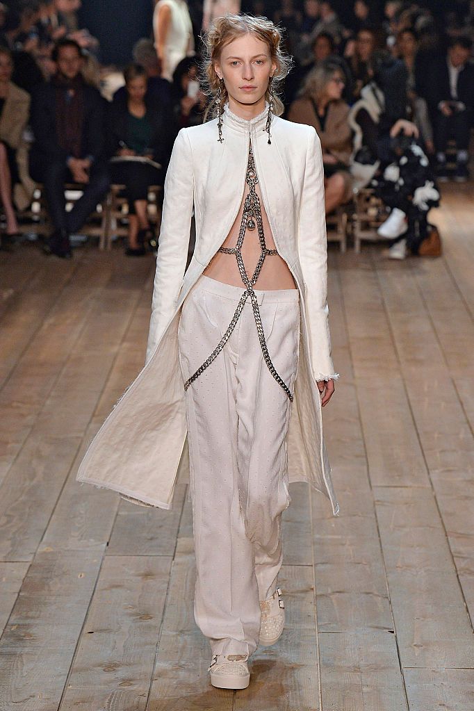 <p>Ook in de collectie van modehuis Alexander McQueen mocht wit niet ontbreken. Sarah Burton liet zich inspireren door de Londense zijdewevers uit de 17e eeuw maar gaf er een moderne draai aan door veel grote sieraden, net als deze body chain tot over de heupen. </p>