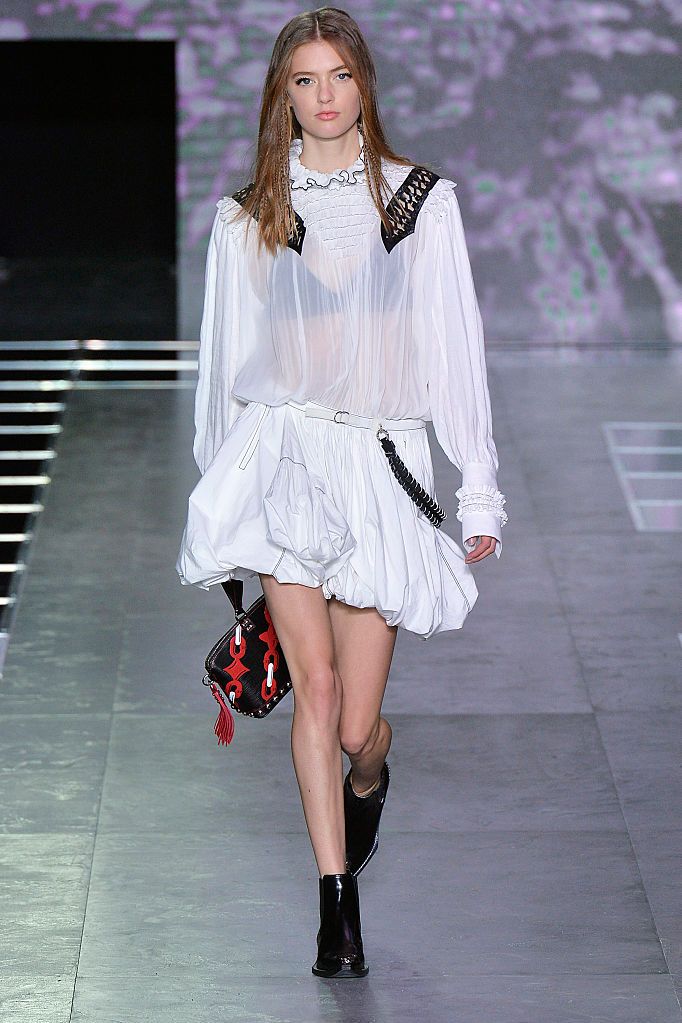 <p>Cyberpunk, was het thema op de catwalk van Louis Vuitton. Een witte blouse en dito rok werden stoer gemaakt door zwarte accenten op de schouders en de heup. </p>
