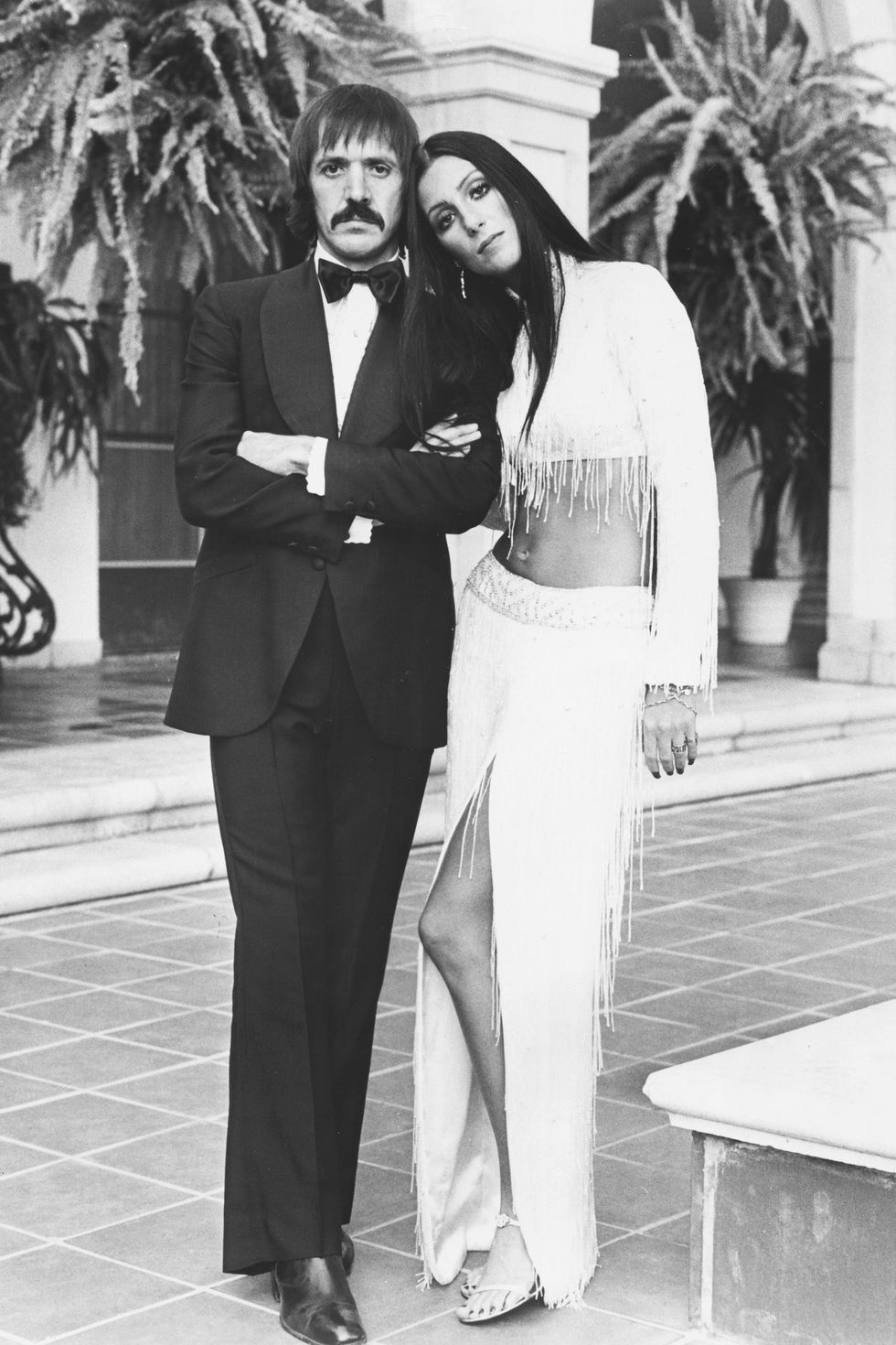 Portrait of singing duo Sonny Bono and Cher, wearing formal dress on an outdoor patio, circa 1975. (Photo by Archive Photos/Moviepix/Getty Images)
