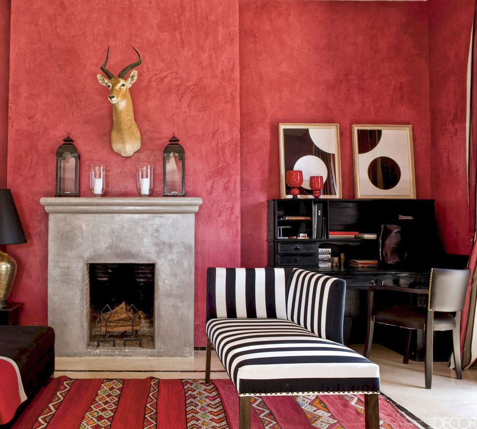 <p>In a <a href="http://www.elledecor.com/home-remodeling-renovating/home-makeovers/g1060/morrocan-house-studio-ko/" target="_blank">Moroccan vacation home</a>, the salon walls are coated with a striking red stucco and a taxidermy antelope hangs above a fireplace covered in <em data-redactor-tag="em">tadelakt,</em> a traditional Moroccan plaster technique. The chaise is upholstered in a striped fabric from Toiles de Mayenne, and silk-screened prints by Gerhard Doehler sit above the desk.</p>