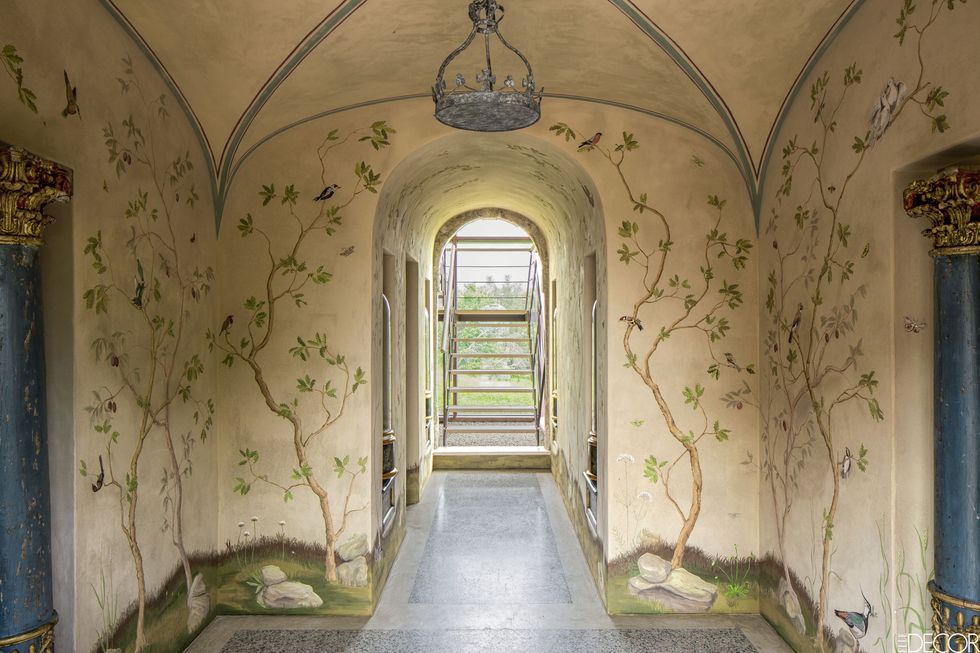 <p>For the entrance hall of a 17th-century farmhouse on the border of Italy's Tuscany and Umbria regions, designer Eric Egan commissioned Florentine decorative painter Francesca Guicciardini to create a whimsical mural of birds and botanicals. The tole light fixture is custom made, and the flooring is terrazzo.</p>