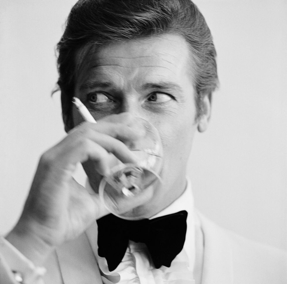 English actor Roger Moore, downs a Martini, 17th July 1968. Moore has recently been awarded his second Bravo Otto award for most popular television actor, by German magazine Bravo, for his mystery spy thriller television series, 'The Saint'. (Photo by Peter Ruck/BIPs/Getty Images)