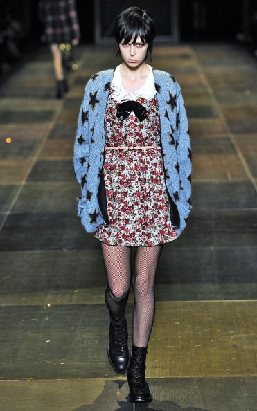<p>七O、八O年代Yves Saint Laurent喜愛的閃亮薄紗屢次出現在這次的系列之中，當年Naomi Campbell在伸展台上穿的奢華綠皮草一改成為粉紅色，Hedi也將Belle de Jour Dress與棋盤格紋擦撞出新的火花。而這一系列裡的星星針織外套更是成為當時最熱門的單品，連好萊塢女明星們都趨之若鶩。</p>