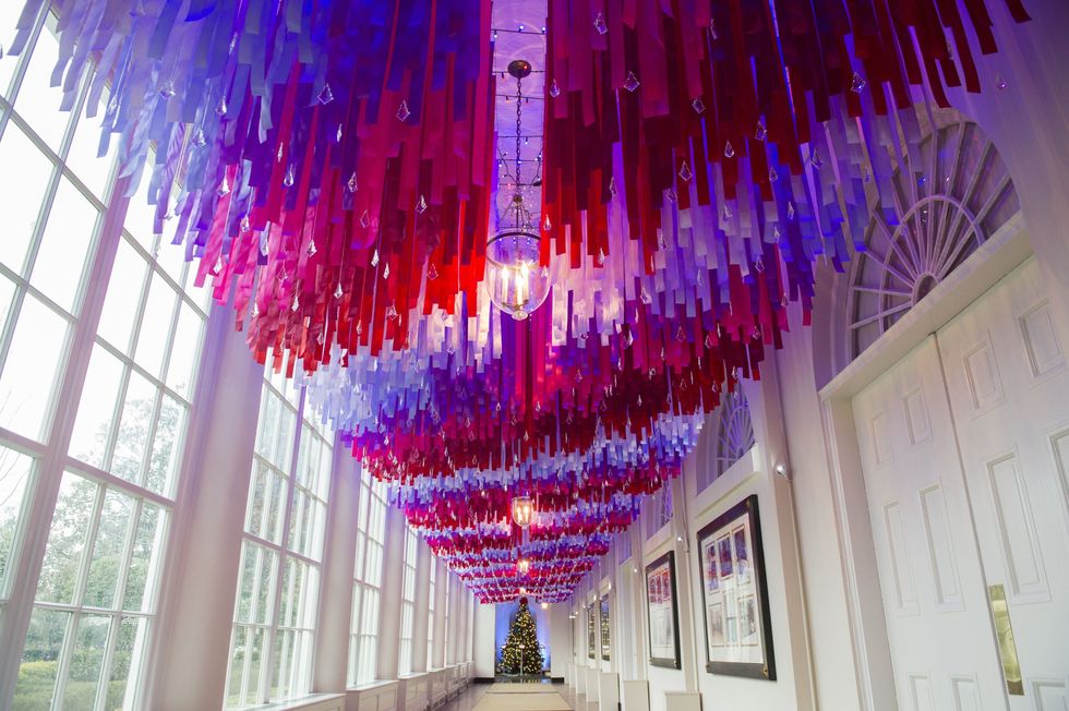 <p>倚著窗戶的走廊天花板上，垂著數不清的紅、紫、粉色的彩帶，一直開展到底部的聖誕樹前。</p>