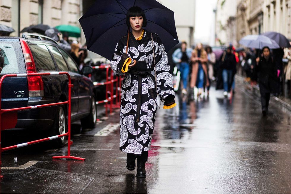 Street fashion, Umbrella, Rain, Fashion, Pedestrian, Street, Urban area, Outerwear, Precipitation, Fashion accessory, 