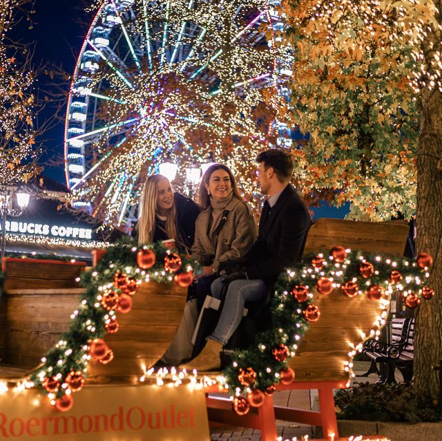 mcarthurglen beeld van drie mensen in een verlichte arreslee met kerstversiering in designer outlet