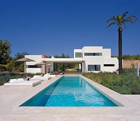 la casa, concebida en tres cuerpos cúbicos y de baja altura, se acomoda con total naturalidad a la vegetación mediterránea