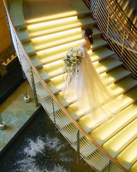 グランド ハイアット 東京の2階とロビーを繋ぐらせん階段に佇む花嫁の写真。