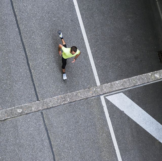 man hardlopen auto straat alleen foto van boven genomen