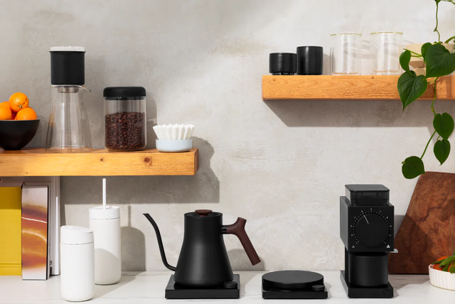 a kitchen counter with coffee cups and coffee maker