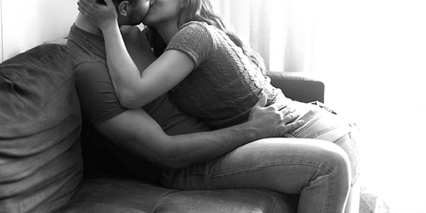 couple kissing on couch wearing jeans