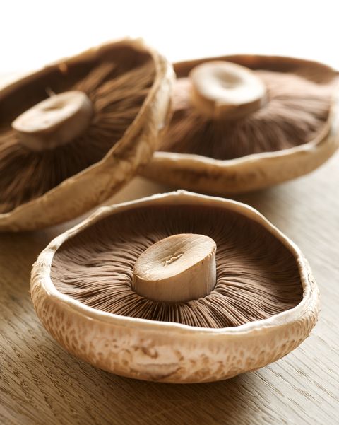 raw portabello mushrooms on a wood surface