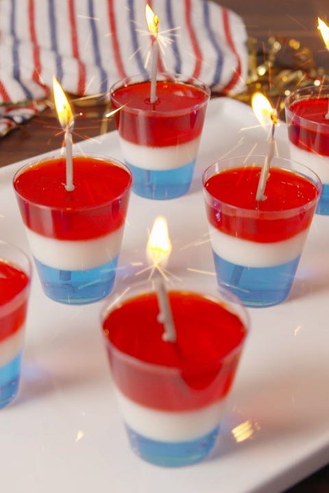 red, white and blue jello shots with candles in them