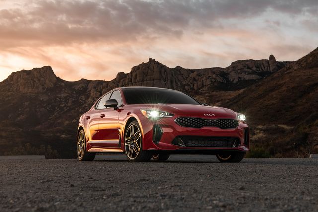 kia stinger gt parked in the desert with mountains in the background