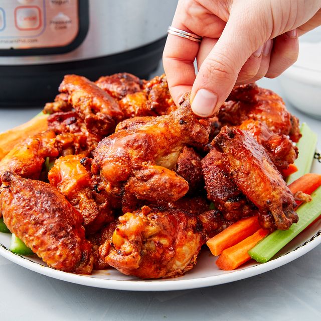 a pile of crispy instant pot chicken wings on top of crudite