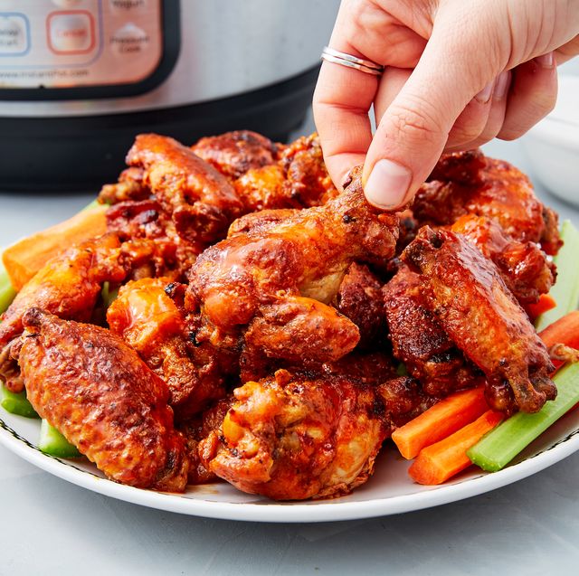 a pile of crispy instant pot chicken wings on top of crudite