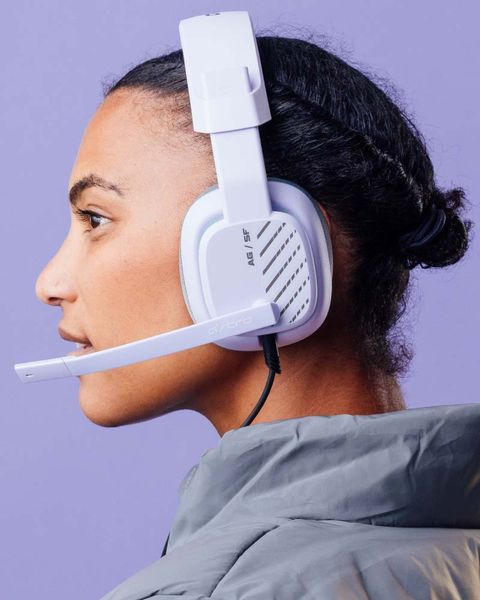 a person wearing logitech astro a50 x headphones in white