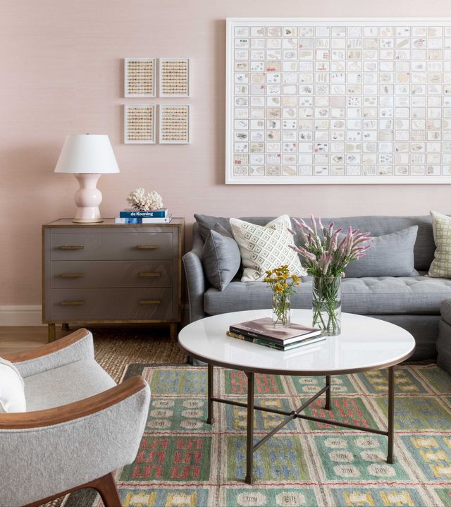 pink wallpaper, gray sofa, circular coffee table, wall art
