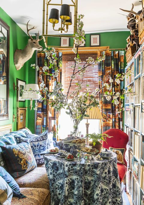 dining area, green painted walls, deer head, bookcase with books,