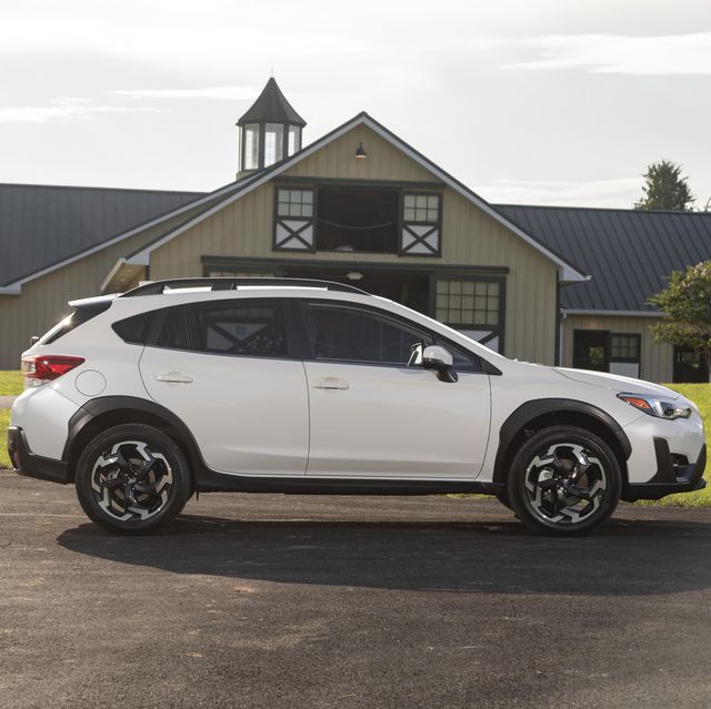 subaru crosstrek viewed from the side while parked with horse stables in the background