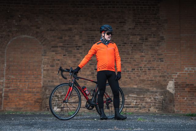 wielrennermet silvini ghisallo jacket en rapone pad fietsbroek voor de winter met racefiets voor een bakstenen muur