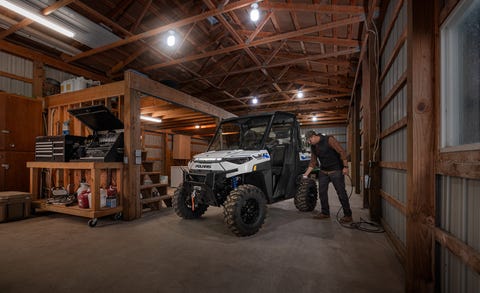 a polaris ranger xp kinetic charging in a barn