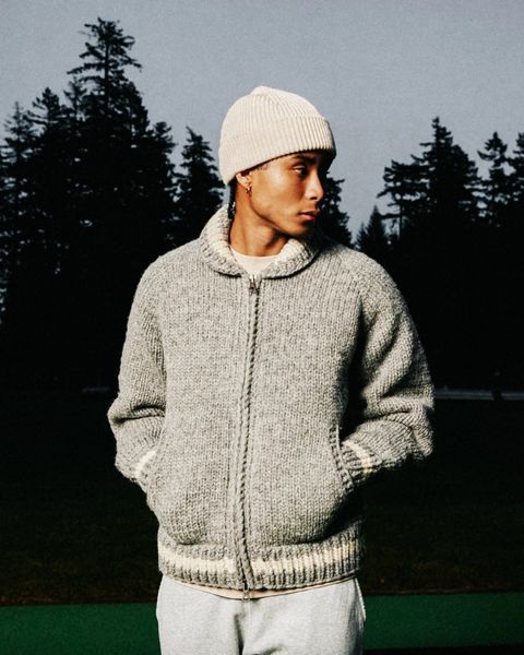 a person wearing a reigning champ handknit varsity sweater