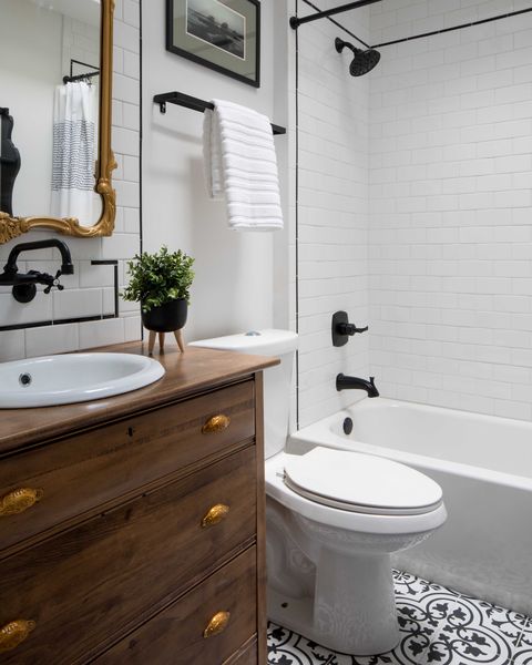 white bathroom, wooden sink and drawers, black faucets and details