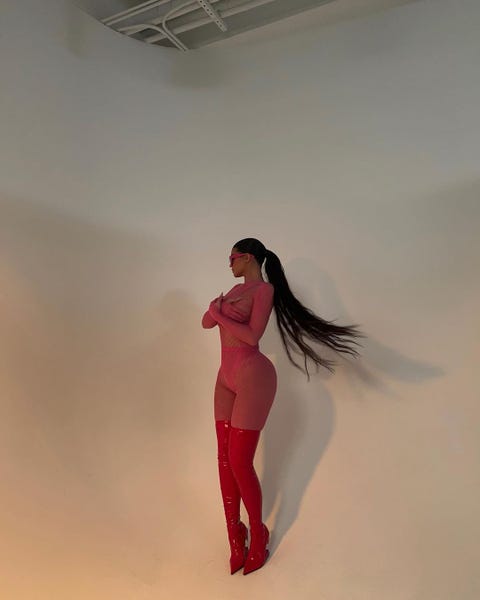 Kylie Jenner Poses in Hot Pink Fishnet Catsuit & Thigh-High Boots