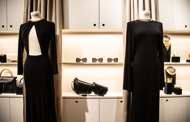 detalle del interior de la tienda de juanjo oliva en parís con dos vestidos negros y accesorios detrás