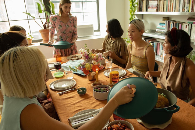 a group of women sitting around a table with food