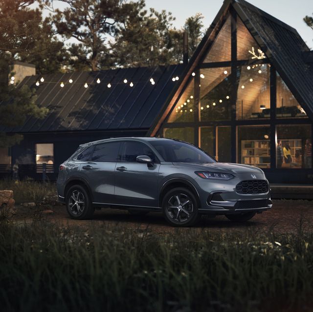 2023 honda hr v ex l parked in front of a fancy wood and glass home in the woods