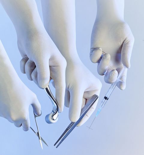 two pairs of hands in surgical gloves holding different medical tools, tweezers, scissors