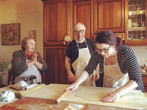three people in kitchen making pasta in italy