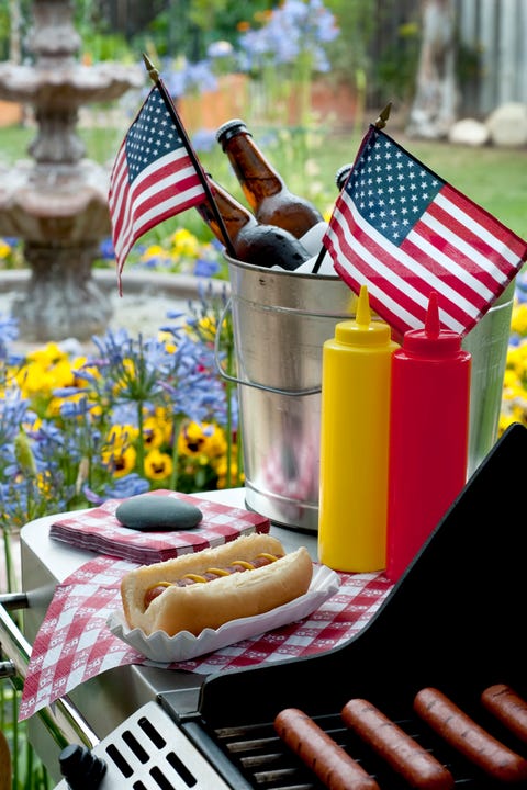 Bucket with beer and hotdogs grilling in backyard bucket with beer and hotdogs grilling in backyard