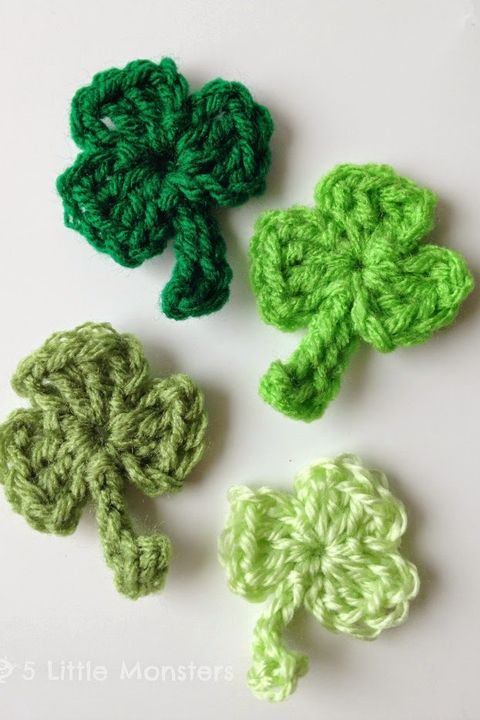 four crocheted shamrocks in 4 different shades of green