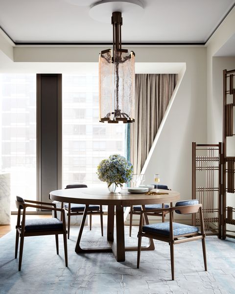 Midcentury-modern table surrounded by chairs with gray-blue cushions. 