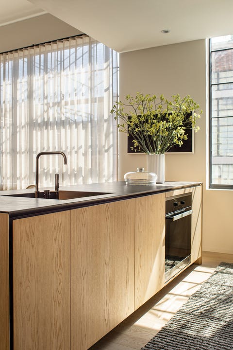 wooden kitchen island, black countertops, wool runner, white vase, faucet