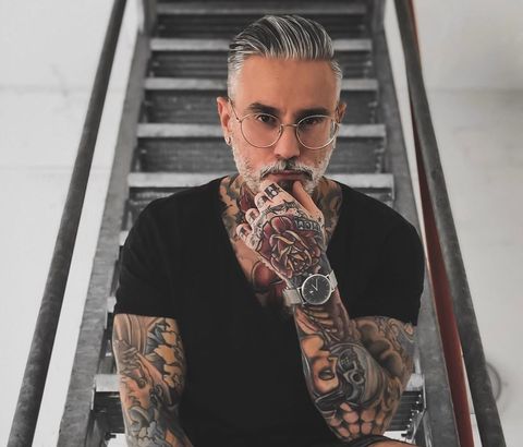 Man met tattoos en grijs haar