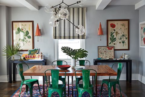 colorful dining room with green chairs and vintage art