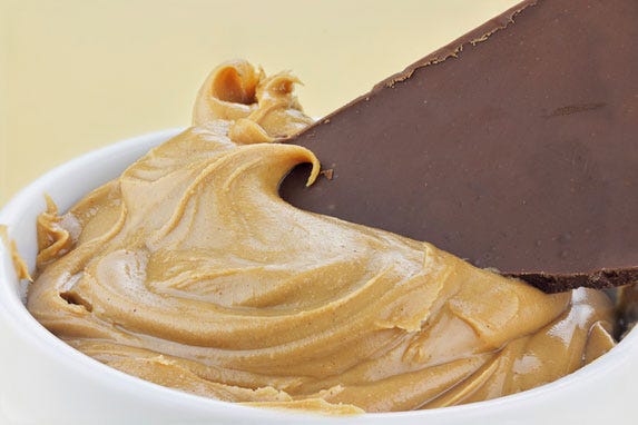 Bakje met pindakaas en een stuk chocolade.
