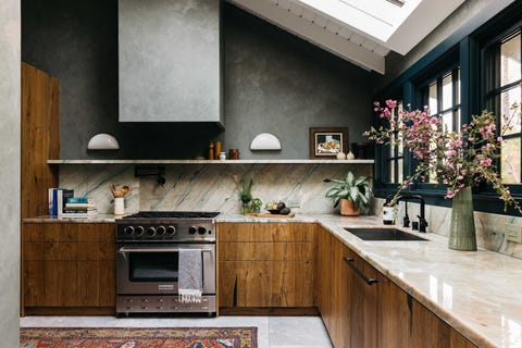 kitchen with wooden cabinets, green window trim, marble countertops and backsplash,
