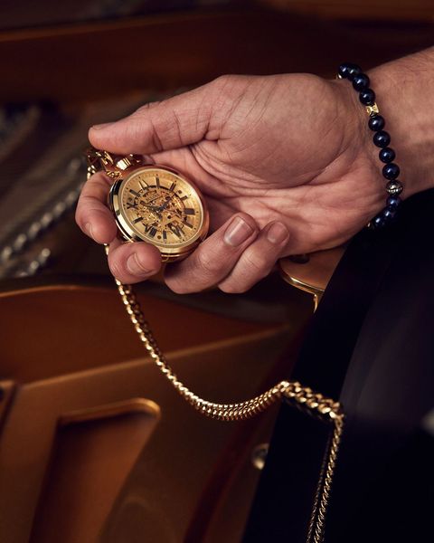 a person holding a bulova sutton pocket watch
