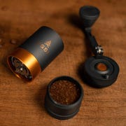 deconstructed hand coffee grinder on wood