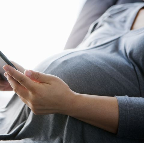 a pregnant woman using a digital tablet
