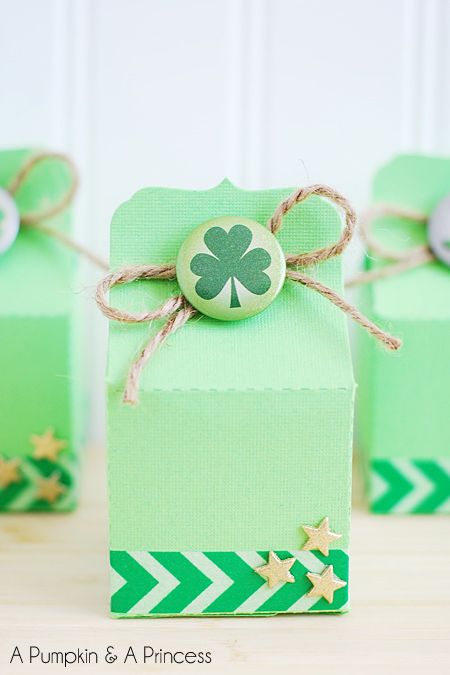 green treat box decorated with washi tape and small gold stars at the bottom and jute string and a shamrock pin at the top