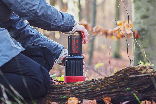 person making coffee with the aeropress go portable travel coffee press in the woods