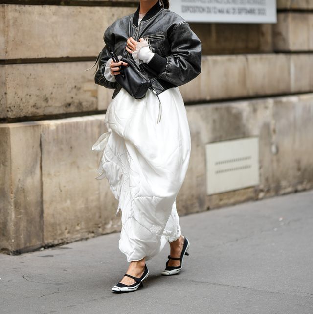 paris, france   september 28 sophia roe wears a black shiny leather jacket, a white long puffy dress, a black shiny leather zipper handbag, silver rings, black and white heels shoes from dior , outside cecilie bahnsen, during paris fashion week   womenswear springsummer 2023, on september 28, 2022 in paris, france photo by edward berthelotgetty images