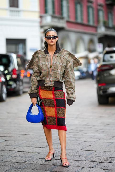 milan, italy   september 21  melanie darmon wears a gold hair clip, black sunglasses, gold earrings, a brown with blue and red checkered print pattern oversized jacket, a royal blue shiny leather handbag from coperni , a red  black  white embroidered wool pattern knees skirt, black and red strappy heels sandals, outside fendi, during the milan fashion week   womenswear springsummer 2023 on september 21, 2022 in milan, italy photo by edward berthelotgetty images